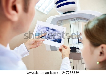 The doctor shows the patient an x-ray image. Computer diagnostics. dental tomography Royalty-Free Stock Photo #1247738869