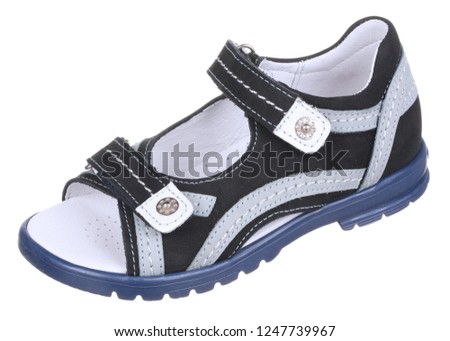 Side upper view of black, gray, blue and white suede boy sandal with slits and slots, perforated insole and two velcros, isolated on white