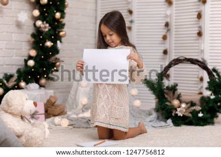 Cute smiling child girl writing letter to Santa Claus at home