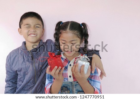Happy with the children's smile, in the girl's hand there is a gift box for the New Year's Christmas gifts.