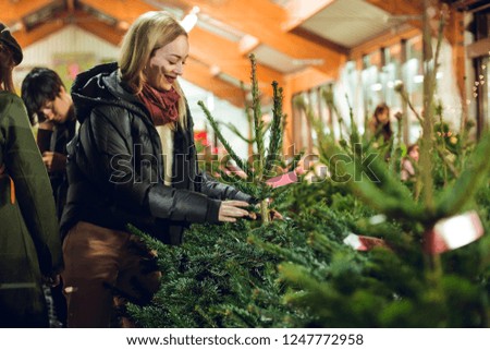 Blonde girl looking at Christmas trees