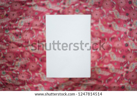 White empty paper blank isolated for your design at bright red pattern blurred bokeh background flat lay mock up
