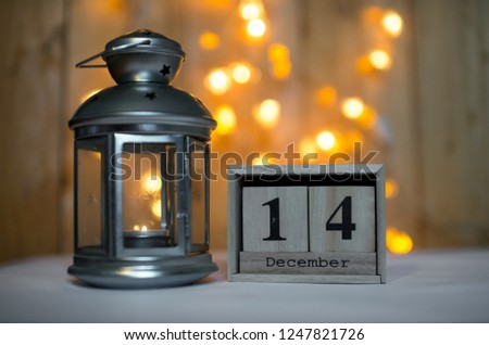 Cube wooden calendar showing date on 14th December with advent lantern over bokeh background. Advent calendar, Christmas background, Copy space