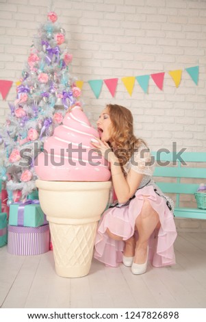 happy young girl with huge pink ice cream on winter christmas background alone