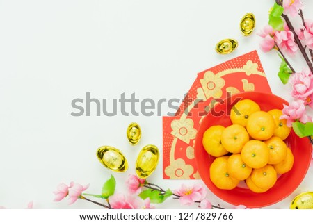 Top view aerial image shot of arrangement decoration Chinese new year & lunar new year holiday background concept.Flat lay fresh orange with pink cheery blossom & red pocket money on  white wooden.