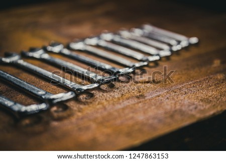 close up Picture of a spanner on a old vintage board in a black background