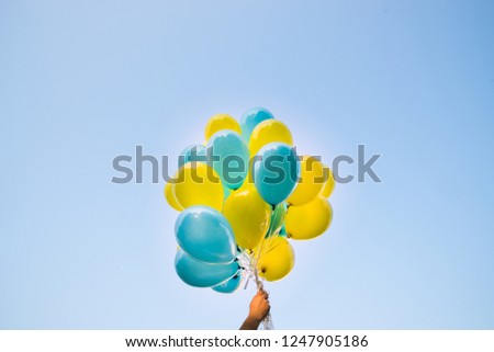 Blue and yellow balloons in colors of the Ukrainian flag fly in the sky, balloons background