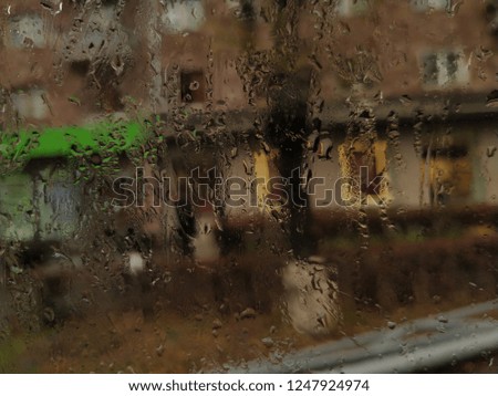 artistic city view in rainy day  through window with raindrops

