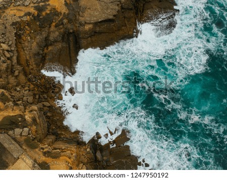 Aerial drone top view of rocky coastline on sunny summer day