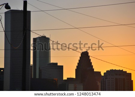 Downtown Houston’s skyscrapers create a silhouette against a late afternoon sky.