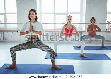 Group of young healthy woman doing yoga exercise together indoor class. Healthy lifestyle concept