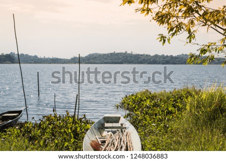 A fishing boat for fishing in the lake, a green iron boat on the shore.