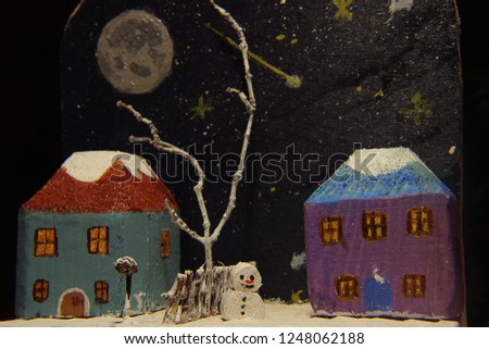 Wooden handmade decoration, christmas theme, little snowman two neighbors and tree at night, moonlit sky with stars