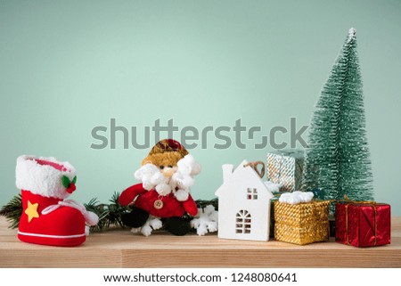 Christmas background. A small Christmas tree and boxes with gifts on a wooden table. Green background. Space for text. New Year's background.