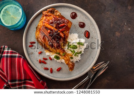 Duck leg confit with rice and goji berries. Traditional french cuisine. View from above.