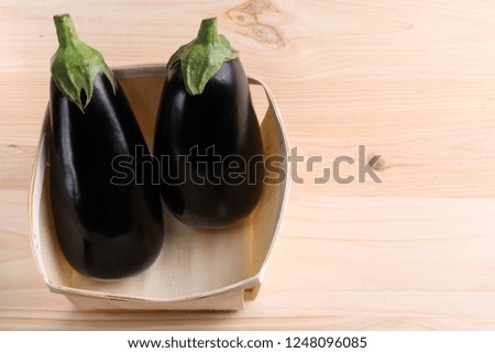 Eggplant in a wooden bowl on a wooden table