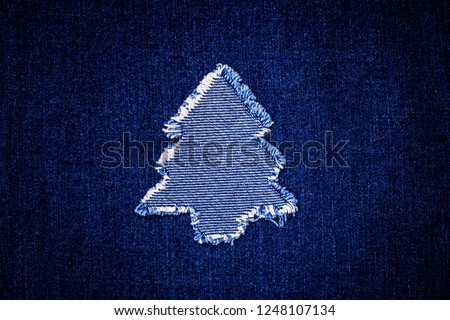 Christmas fashion background with denim Christmas tree patch on blue denim cloth
