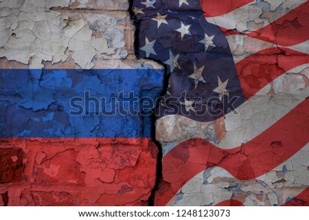Brick wall with a crack painted on different sides in the American and Russian flags