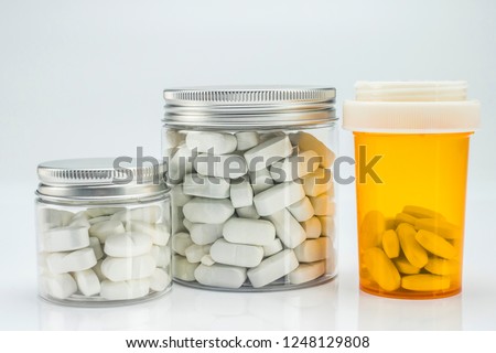 Different types of bottles with pills, isolated on white background, conceptual image