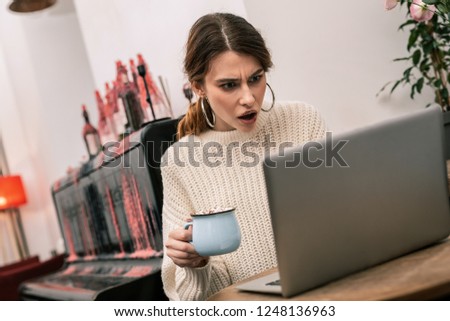 Receiving new edits. Outraged freelancer receiving a mail from the client while working in a cafe with her computer