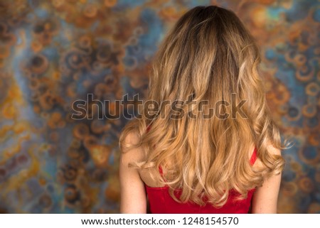Female Long wavy blonde hair, rear view, studio wall background