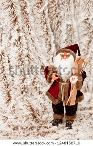 Toy Santa holds a garland in his hand