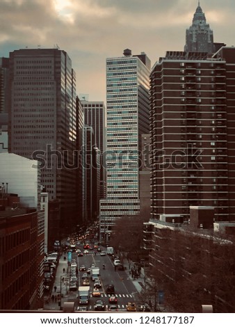 Picture was taken in New York City and is a beautiful shot of various buildings as well as some nice scenery from traffic.
