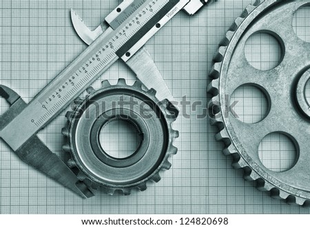 gears and caliper on graph paper Royalty-Free Stock Photo #124820698