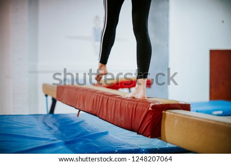 Young gymnast balancing on a balance beam Royalty-Free Stock Photo #1248207064