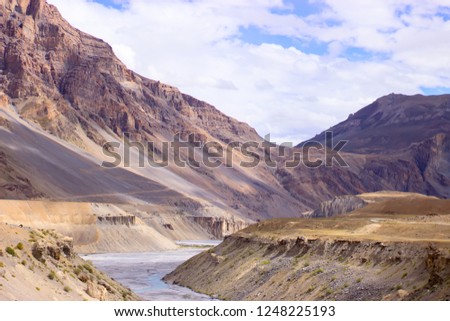 Beautiful picture of a mountain river among the sand dunes and clouds. Trekking concept.