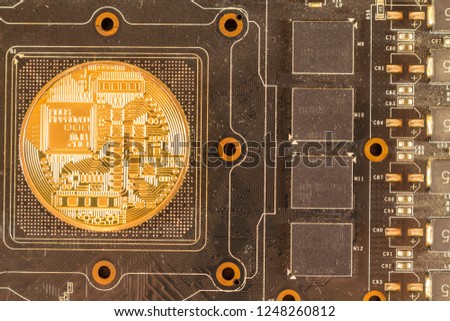 Bitcoin coin lies on the video card close up