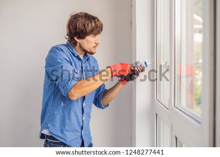 Man in a blue shirt does window installation