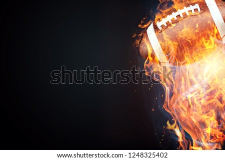 American football game. Soccer ball enveloped by fire. The concept of sport, wrestling, speed, opposition. Mixed media, copy space.