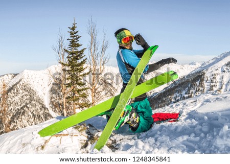 Skier freerider doing yoga skiing in snowy mountains