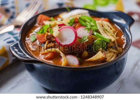 Hearty and spicy chicken tortilla soup with hot peppers and radish garnish
