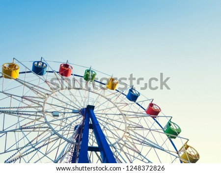 Underside view of a ferris wheel over blue sky