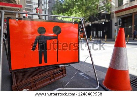 Red traffic controller stopping sign ahead on the pedestrian road side in Sydney down town busy street, Sydney CBD, Australia 