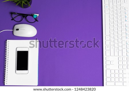 White computer keyboard on a bright purple paper background