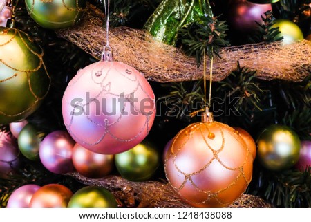 Colorful balls hanging from a decorated Christmas tree.