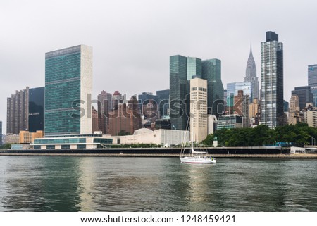 Sailing ship on East River against skyline of Midtown of New York City a misty day