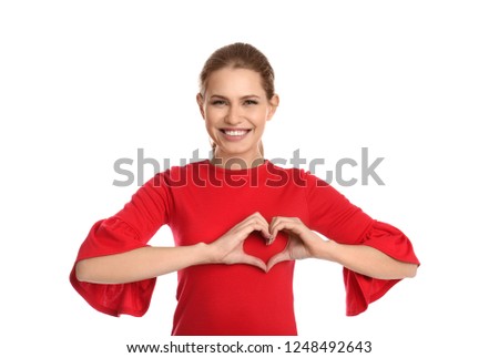 Portrait of young woman making heart with her hands on white background