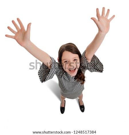 Hands up in the air. Overjoyed girl waving and looking up at the camera. Happiness and success. Royalty-Free Stock Photo #1248517384