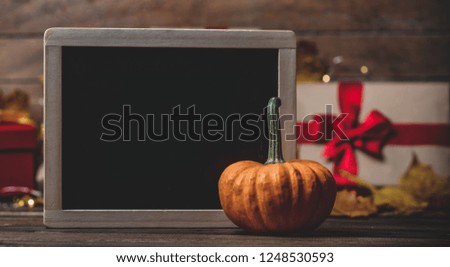 leaves and pumpkin with Halloween gift box and blackboard on Fairy Ligths background. Autumn season image composition