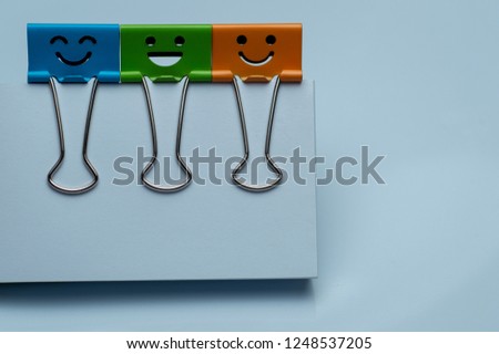 colorful binder clips on white papers, happiness character.