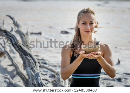 young beautiful girl with a singing bowl is meditating in nature sitting on the lake