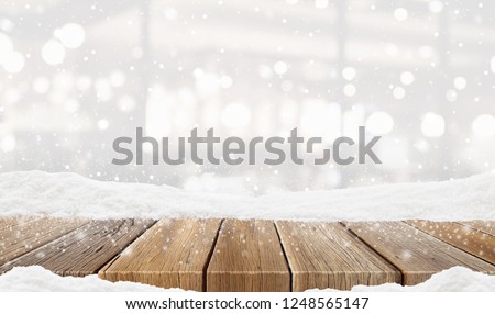 Closeup top wood table with Blur Background and snow christmas time, for your photo montage or product display, Wood table top on blur Christmas tree in snow, Space for placing items on the table.