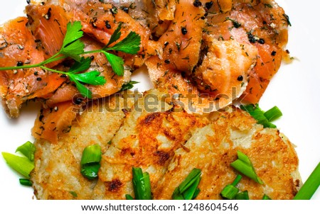 potato pancakes with salmon and fresh onion, parsley, black pepper background