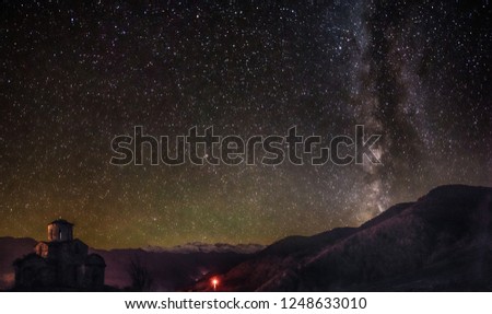 old abandoned Senty church in front of Caucasus mountain range and Milky way during clear starry night