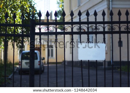 Blank white sign on the fence with blurred background