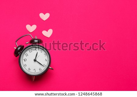 alarm clock and hearts on color background. Place for text.